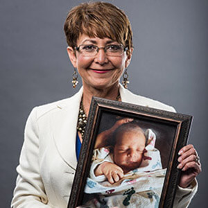 Vicky Clarke holding a framed photo of a baby