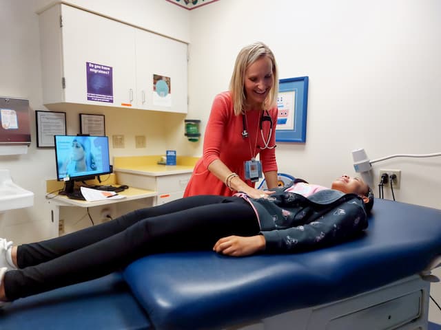 Provider examining a patient on an exam table during a clinic visit.