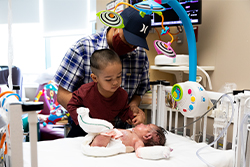 Baby Jaciel being visited by his younger brother and father at Children's Mercy.