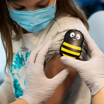 A Buzzy® bee being applied to a child's arm.