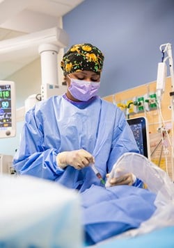 Dr. Gina Patel places a central line in a CICU patient.