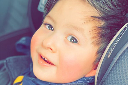 Children's Mercy patient, Elijah, in his car seat and smiling.