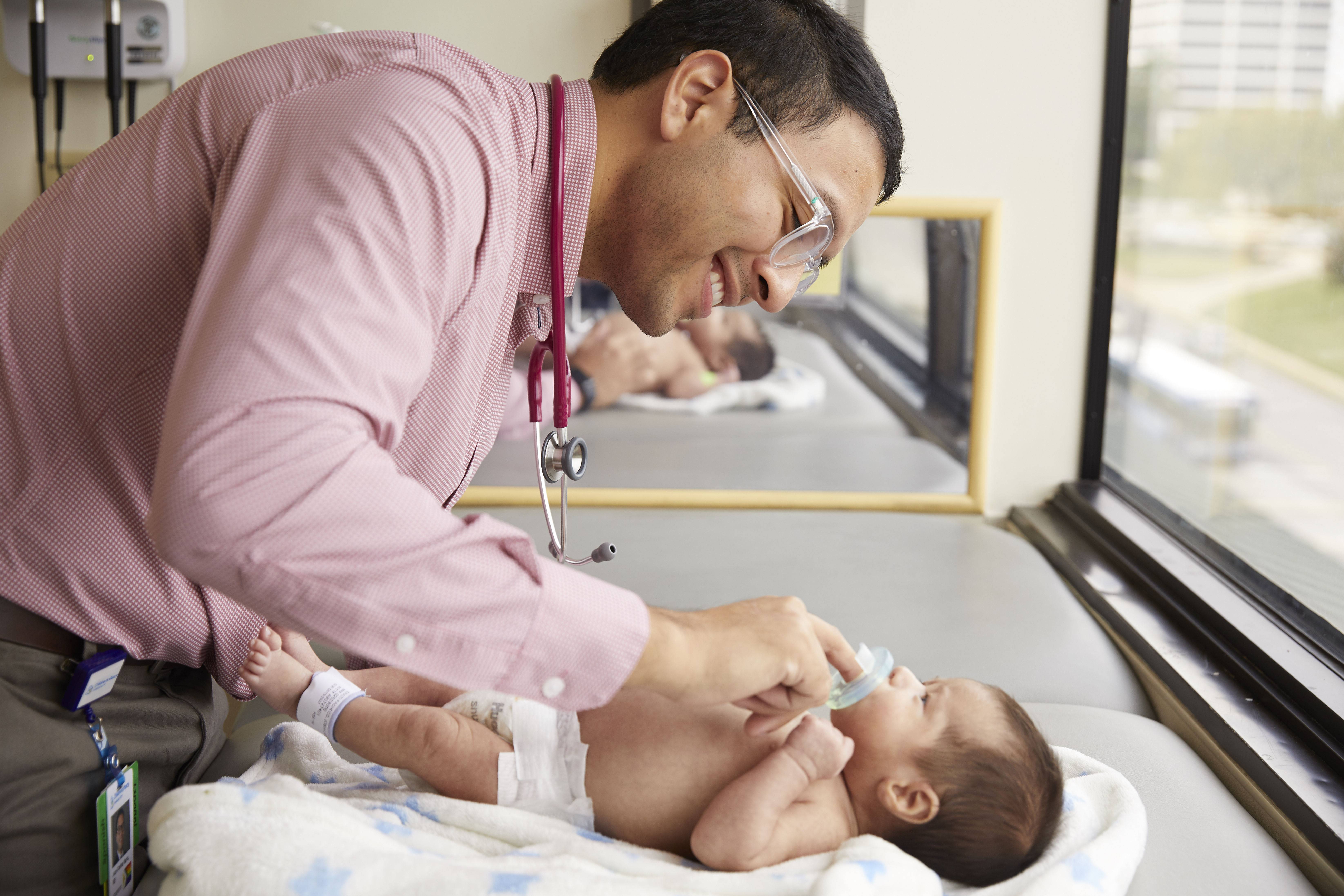 Resident examining child on table