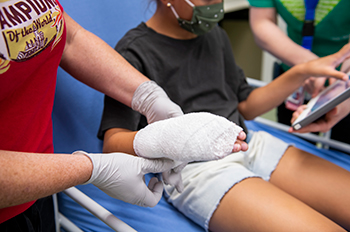 Close-up of a girl's hand wrapped in bandages.