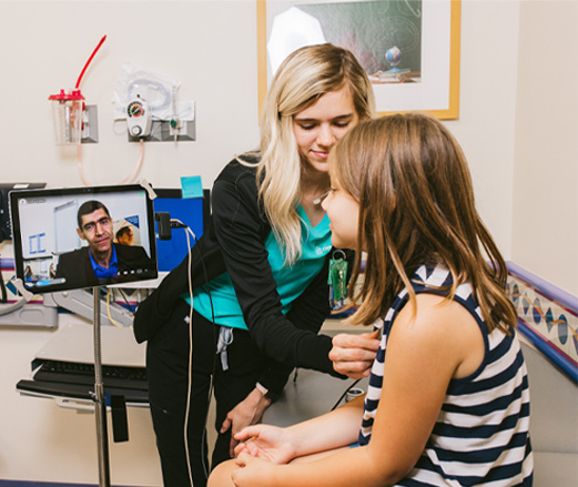 Photo of health care provider and child having a telemedicine visit in hospital