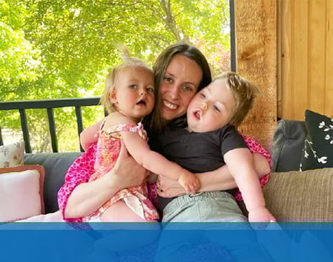 Callum and his sister being held my their mom on hwer lap.