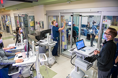 Dr. Nathan Lavoy teaching the multidisciplinary team on rounds in the PICU.