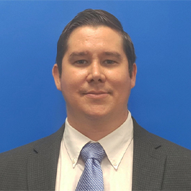 Moises Alatorre Jimenez, MD, PhD smiling and wearing a suit.