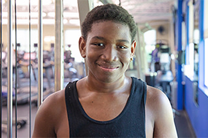 An adolescent boy smiles in a sports medicine center.