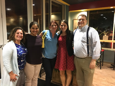 Five members of the Children's Mercy Child Neurology Residency team pose together in a restaurant.