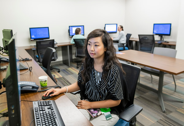 A female physician uses a computer in an office setting.