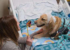 The EMU tech instructs Hope to blow on the pinwheel for testing at Children's Mercy.