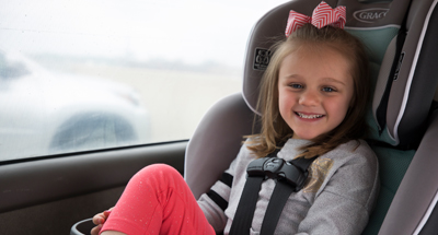 A child smiles in a car seat for the Center for Childhood Safety at Children's Mercy.