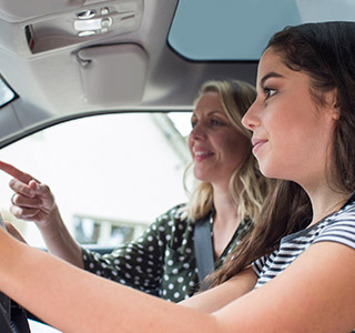 Mom teaching teenage daughter how to drive