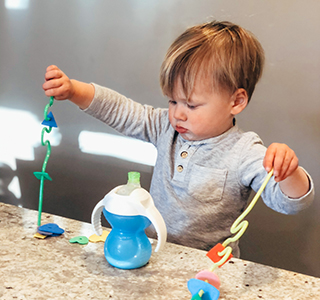 Toddler playing with cups and straws