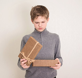 Kid opening present box and frowning