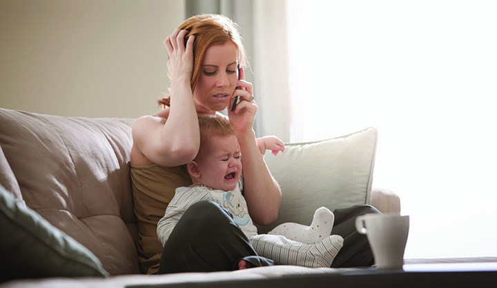 Mom on the phone frustrated while baby is crying