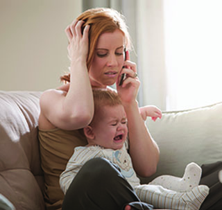 Mom on the phone frustrated while baby is crying
