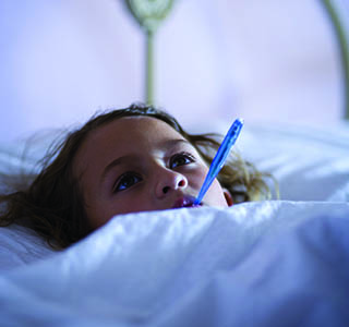 Girl in bed with thermometer