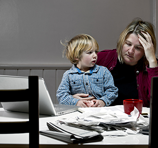 Frustrated mom at table looking at papers