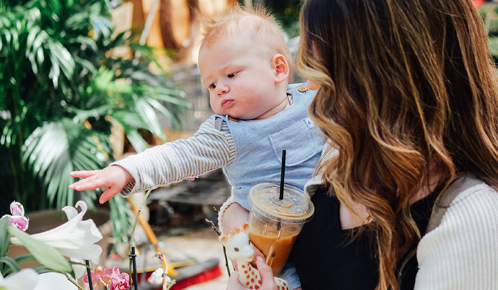 Mom holding baby who points
