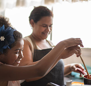 Mom and daughter cooking on stove