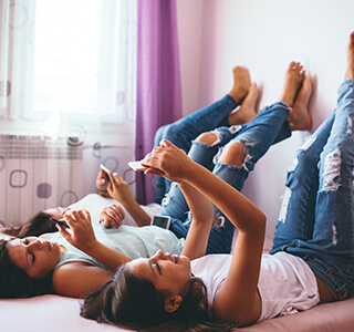 teenage girls lounging and playing on phone