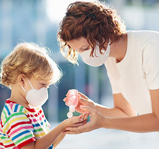 Mom putting hand sanitizer in child's hand