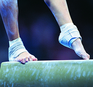 Woman's feet on gymnastic balance beam