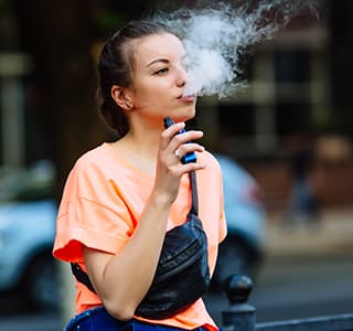 Young girl vaping outside