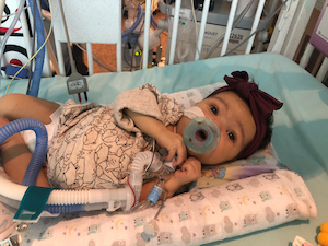 Patient, Birdie, in hospital crib as an infant