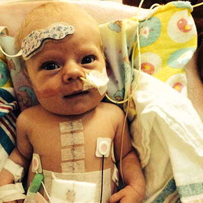 Baby in a hospital bed with medical monitors attached