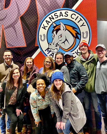 Children's Mercy Pediatric Residents pose together in front of the Kansas City Mavericks logo.