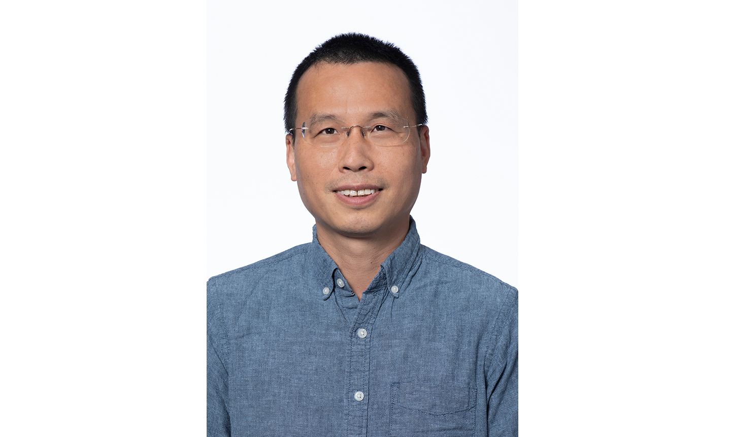 Sheng Xia, horizontal photo. He has short black hair and is wearing glasses.